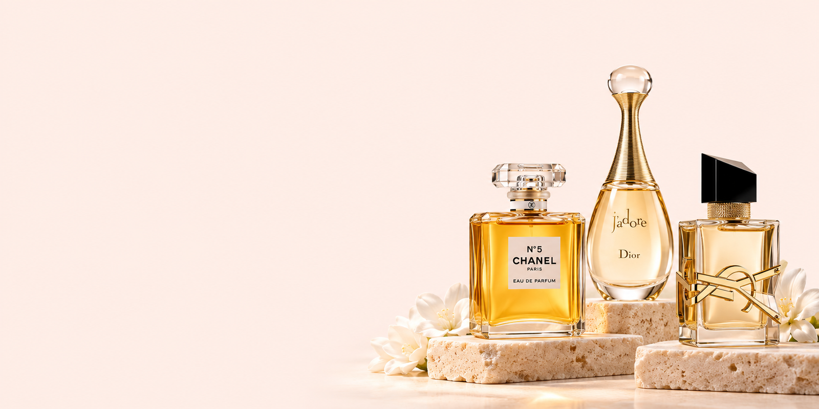 Designer perfume bottles displayed on ivory stone plinths against a pale peach background.